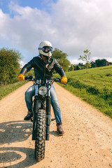 Young man with helmet riding a custom motorbike outdoors