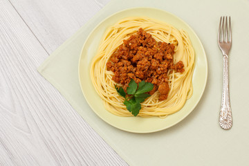 Spaghetti bolognese on a plate with metal fork.