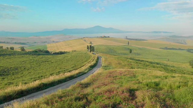 Landscape scenery early in the morning at Pienza in Val d&rsquo;Orcia, Tuscany in Italy, with cypresses trees and green field with beautiful colors on summer day, travel destination in Europe