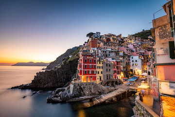 Fototapeta na wymiar Riomaggiore, Italy is a charming village built on a hillside above the Ligurian coast known for its colorful stone houses that seem stacked on top of one another.