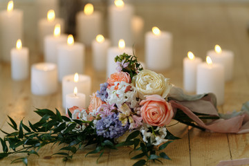 wedding bouquet on the floor with many candles