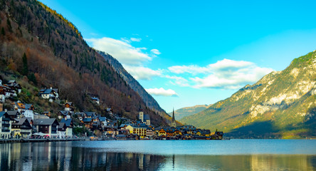 Hallstatt, austria mountain town, on the bank of the lake, beautiful houses, on the background of high mountains, mountains covered with trees and pines, beautiful sky, beautiful nature, lake