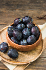 Juicy plums wooden utensils on a wooden table. Rustic style