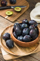 Juicy plums wooden utensils on a wooden table. Rustic style