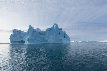 Fototapeta na wymiar Nature and landscapes of Greenland or Antarctica. Travel on the ship among ices. Studying of a phenomenon of global warming Ices and icebergs of unusual forms and colors Beautiful sunny and cloudy day