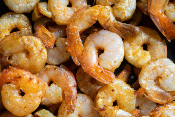 Tasty appetizing juicy peeled fried shrimp in a pan close-up.
