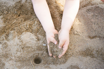 mains d'enfant dans le sable