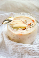 selective focus, still life, Breakfast. berry light peach yogurt with cereals in a glass jar with peach slices on a white tablecloth