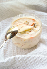 selective focus, still life, Breakfast. berry light peach yogurt with cereals in a glass jar with peach slices on a white tablecloth