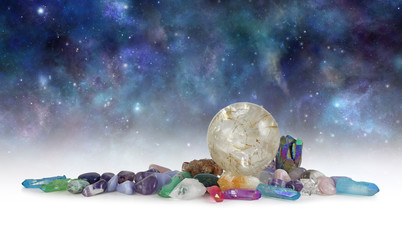 Cosmic Space Crystals Background Banner - Huge rutilated Crystal Ball surrounded by tumbled healing...