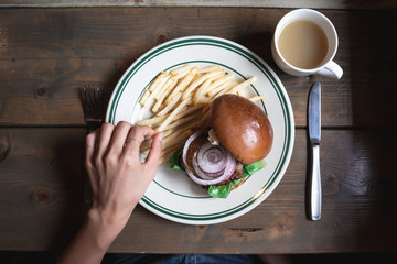 ハンバーガーを食べる人　フライドポテト