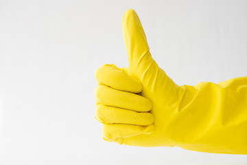hands in yellow gloves, thumb up, white background, sign that all is well,