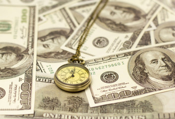 pocket watch and US dollar banknotes