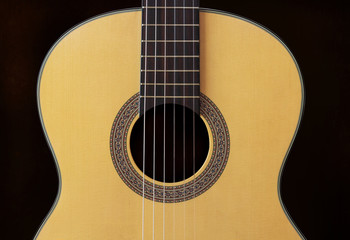 Obraz premium Close-up Wooden Spanish classic guitar with nylon string on the dark background
