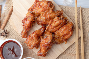 Hot and spicy Korean barbeque fried chicken on wood cutting board