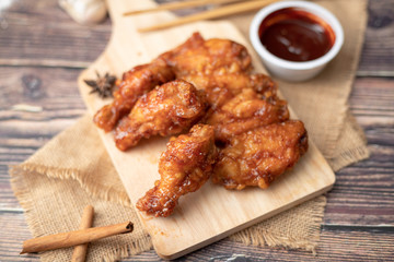 Hot and spicy Korean barbeque fried chicken on wood cutting board