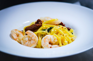 italian sea food pasta dish with fresh vegetables, squid, octopus, shells & garlic