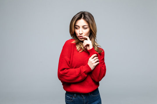 Young woman thinking an idea with red sweater over isolated on gray background