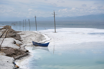 Salt Lake landscape with blue boat, named Chaka Salt Lake, is located in Qinghai Province, China.