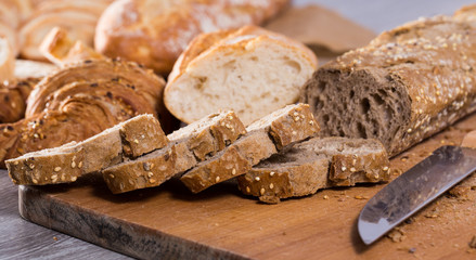 slices of wheaten bread and knife on wooden surface