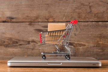 shopping online at home concept.Cartons in a shopping cart on a laptop keyboard.online shopping is...