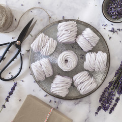 Flat lay with home-made marshmallows made with lavender on white marmor stone background