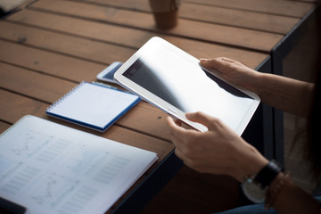 Women's hands with neat manicure and large wristwatch, work with gadgets, tablet, smartphone,...