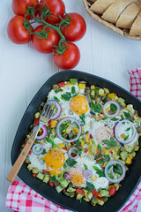 Fried eggs with vegetables in a pan. Shakshuk. Arabic cuisine Proper nutrition. View from above. Space for text.
