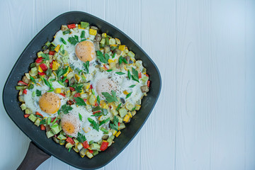 Fried eggs with vegetables in a pan. Shakshuk. Arabic cuisine Proper nutrition. View from above. Space for text.