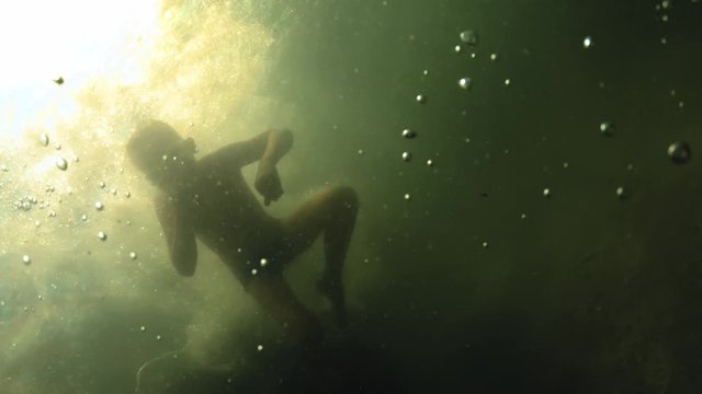 Young Handsome Boy Jumping to the Sea. Children jump into the sea of somersaults. Teenagers jump into the water. Swim under water and play. Summer fun at sea. Slow-motion