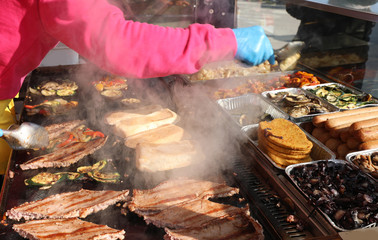 cooking food and sausage on the hot plate of the street food sta