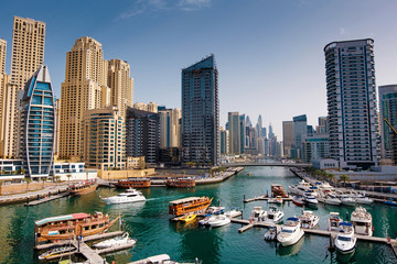 Fototapeta na wymiar Dubai marina with boats and buildings with gates, United Arab Emirates