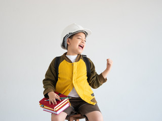 Asian boy with white engineer hat and whiting on the book education concept