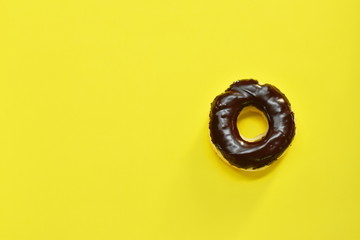 Obraz na płótnie Canvas chocolate cream donuts on yellow foam board background