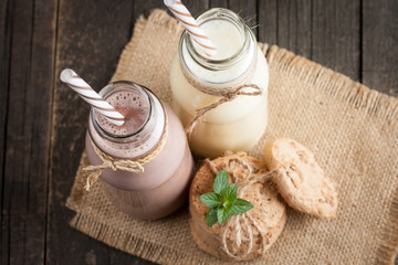 Photo of fresh Made Chocolate Banana Smoothie on a wooden table with cookies, banana and coconut. Milkshake. Protein diet. Healthy food concept.