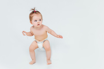 Portrait of small child  holding on her hands a toy, curious baby looking up isolated on white.