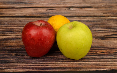 Ripe green and red apples on a wooden table background