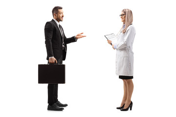 Businessman with a briefcase talking to a young female doctor