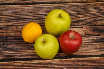 Ripe green and red apples on a wooden table background