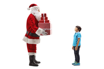 Santa Claus giving a pile of presents to a boy