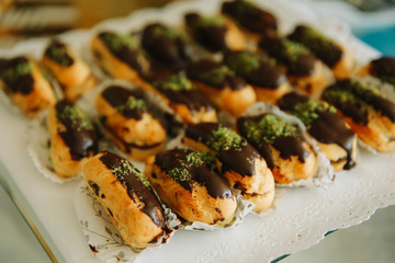 Traditional sweet french eclair or profiterole desserts on the table. 