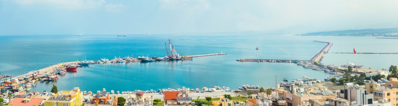 Industrial port or harbor with container or cargo ships and cranes in iskenderun seaport at Hatay city of Turkey. Transportation and logistic at Mediterranean sea. 