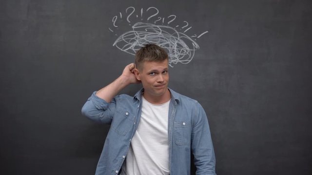 Confused male scratching head against blackboard, lack of experience, solution