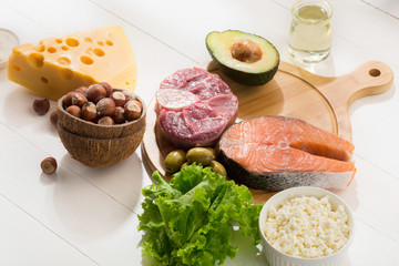 Ketogenic low carbs diet - food selection on white wooden background. Balanced healthy organic ingredients of high content of fats. Nutrition for the heart and blood vessels. Meat, fish and vegetables