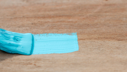  painting a wooden surface. blue paint on the brush