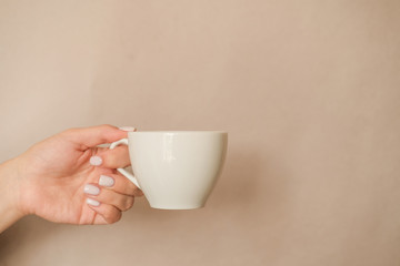 hand holding a white Cup of coffee