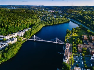 Aerial view of blue lake with cable-stayed bridge and green summer town in Finland.