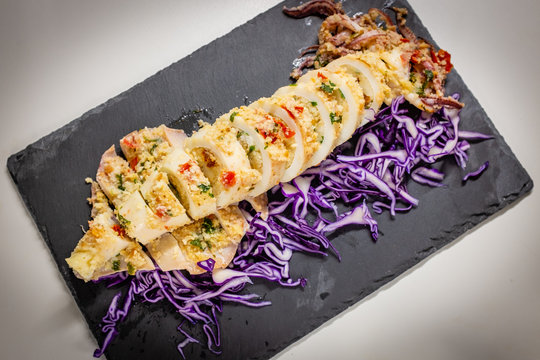Backed squid stuffed with bread, parsil and tomato and side of red cabbage. Italian recipe.