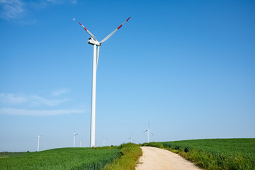 Landscape of Murgia with road heading to a wind farm. Puglia region, Italy