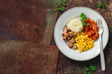 rice, vegetables and meat (corn, tomato salsa, greens, vegetables) portion serving. top food background. copy space